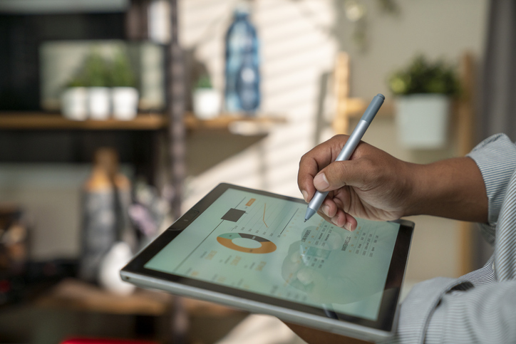 Closeup shot of a businessman analyzing statistics on a digital tablet in an office