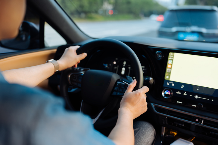 Close up of the hand of a male driver holding a steering wheel driving a car in the city. On the move. Business travel. Car Insurance.